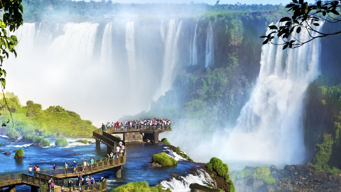 496540104
Landscape; 2015; Falling; Travel Destinations; Paraguay; People; Unrecognizable Person; Iguacu Falls; Argentina; Outdoors; South America; Brazilian; Water; Number of People; Photography; Rainbow; Tourist; Famous Place; Scenics - Nature; Foz do Iguaçu; UNESCO World Heritage Site; Waterfall; iguasu; Brazilian Ethnicity; Argentinian Culture; Puerto Iguazu; Tropical Rainforest; Natural Landmark; Parana State; Iguacu River; Viewpoint; 103626; Iguazú; Journey; New 7 Wonders; Brazil; Vacations; Latin America; Nature; Rainforest; Looking At View; Travel; Tropical Climate; River; International Landmark; Tourism; Awe; The Americas; Horizontal; Iguacu National Park; Environment;
Tourists at Iguazu Falls, one of the world's great natural wonders, on the border of Brazil and Argentina.
